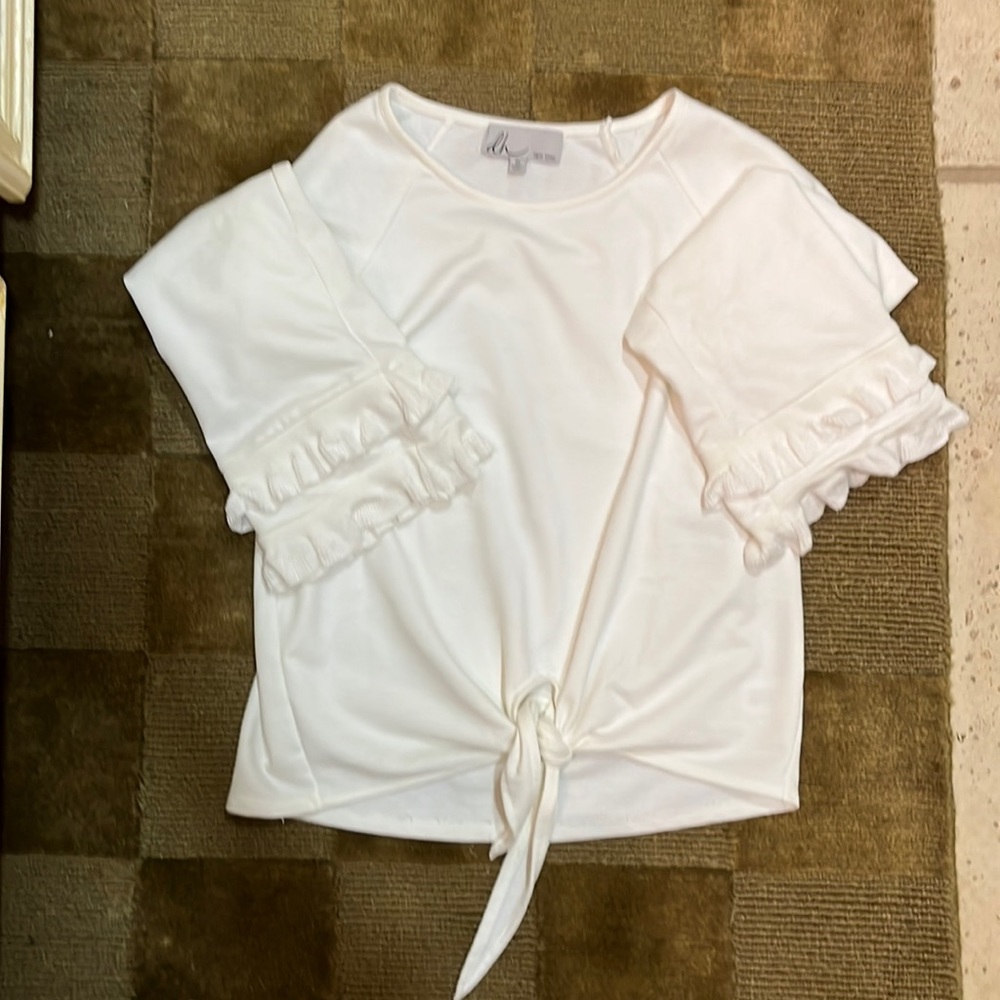 White boutique sweater with ruffle hem sleeves and flirty tie front.